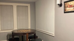 A room with a round table and four chairs, a radiator, a wall-mounted light, and a framed picture. - Family-friendly farmhouse property, rural setting, 10 minutes from Tiffin, OH. (Republic)