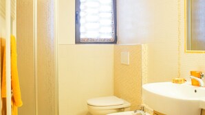 Une salle de bain équipée d’une douche, de toilettes, d’un lavabo et de meubles en bois.