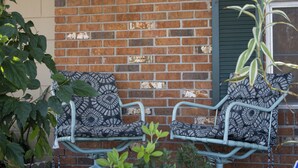 Two metal chairs with patterned cushions against a brick wall. - SHADOW WOOD - King Size Private Suite Sleeps 4, Near Universal, I-Drive, Disney (Pine Hills)