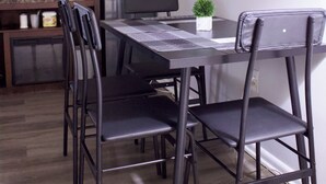 A modern kitchen with a dining table, chairs, a microwave, and a coffee maker. - SHADOW WOOD - King Size Private Suite Sleeps 4, Near Universal, I-Drive, Disney (Pine Hills)