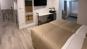 Un dormitorio moderno con una cama grande, un escritorio y un televisor.