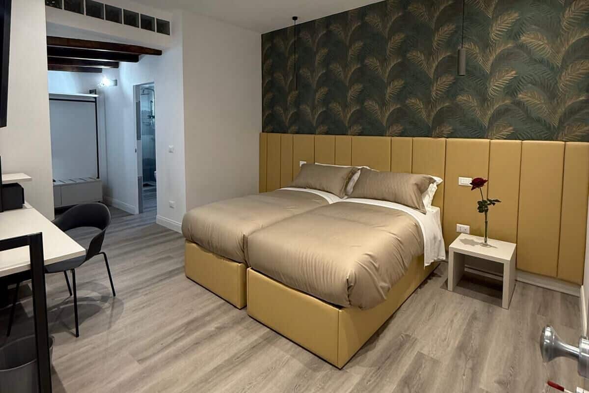 A modern bedroom with a large bed, a desk, and a chair.