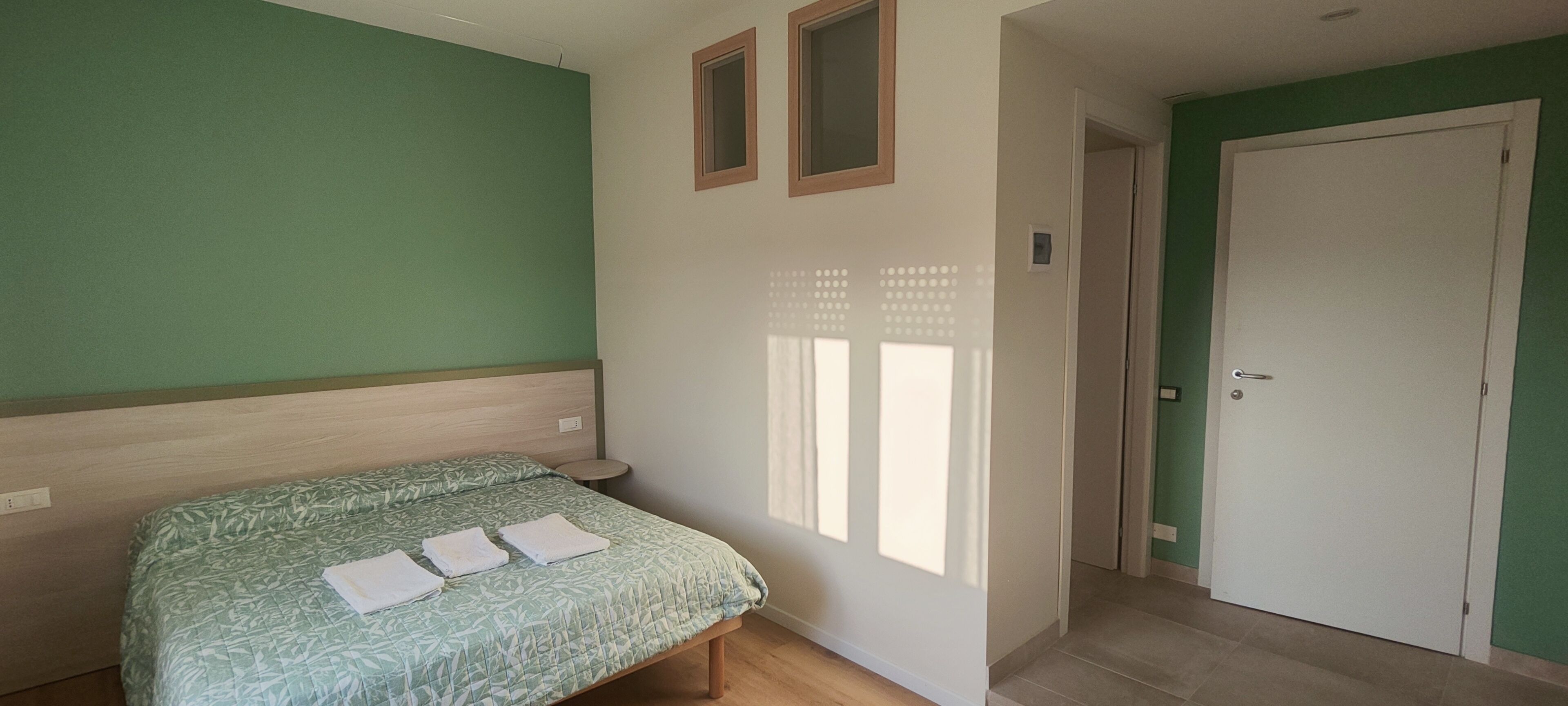 Ein Schlafzimmer mit einem Bett, einer Tür und einem Fenster.