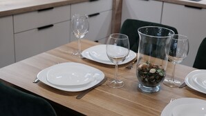 A dining table set with plates, cutlery, and wine glasses, with a decorative bowl in the center. - Apartments Space and More - Apartamenty Wrocław (Wrocław)