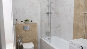 A modern bathroom with a toilet, shower, and built-in washing machine. - Apartments Space and More - Apartamenty Wrocław (Wrocław)