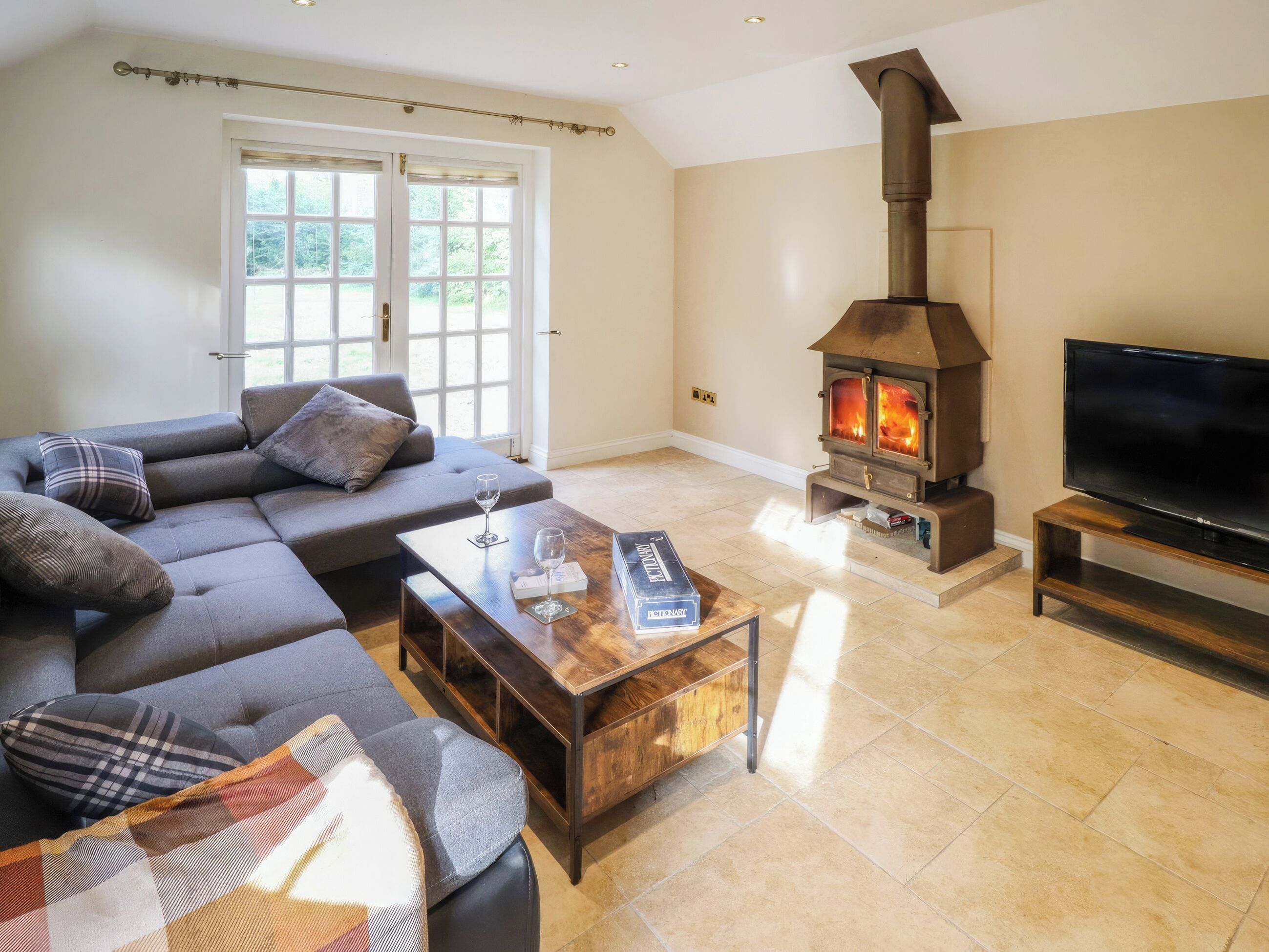 A living room with a sofa, a coffee table, a fireplace, and a TV.