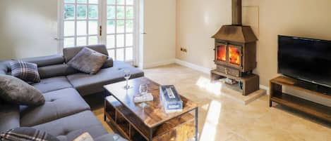 A living room with a sofa, a coffee table, a fireplace, and a TV.