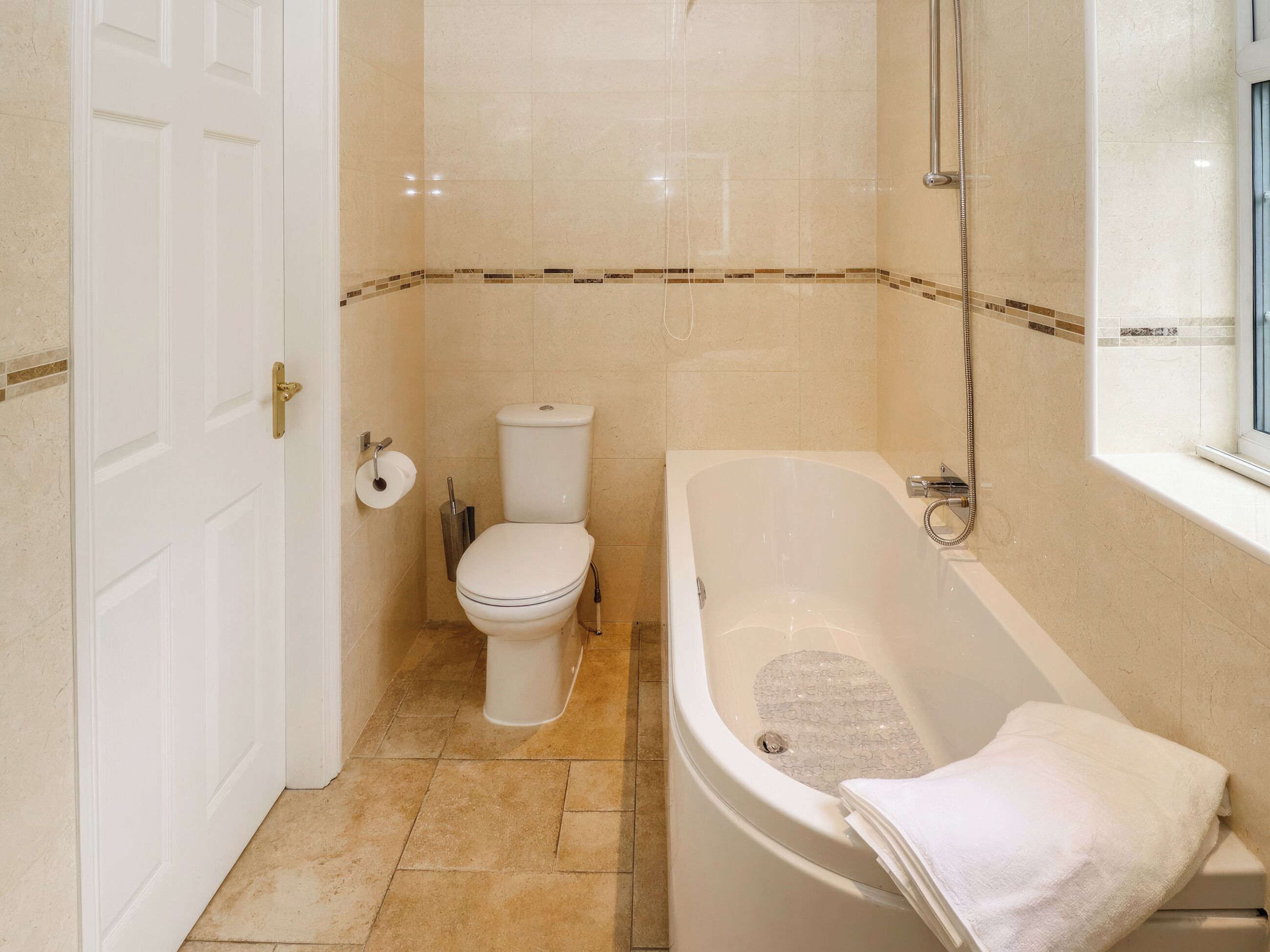 Une salle de bain équipée de toilettes, d’une baignoire et d’une douche.