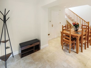A dining area with a wooden table and chairs, a bench, and a coat rack. - 1 bedroom accommodation in Frithville, near Lincolnshire (Frithville, near Lincolnshire)