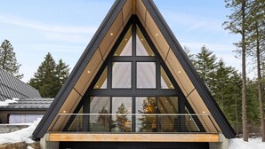 A modern triangular building with large windows and a balcony. - Skegge Retreat - A Mountain Spa (Ronald)