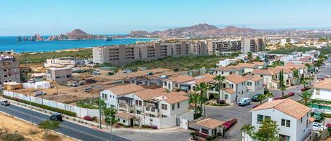Zona residencial con edificios de varios pisos, una carretera y vista al mar.