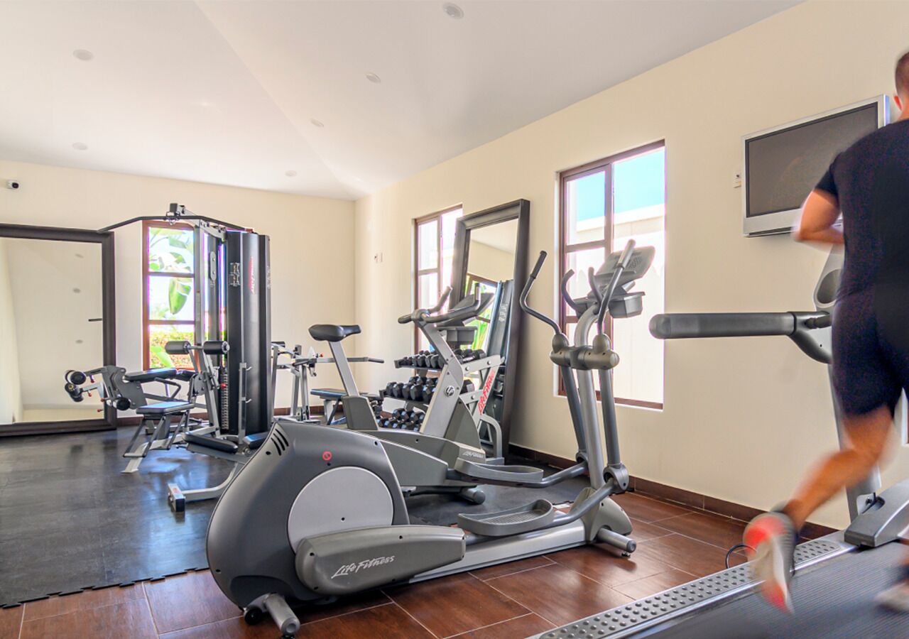 A gym with treadmills, elliptical machines, and weight equipment.