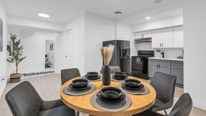 A modern kitchen with white cabinets, a black refrigerator, and a stove. - Budget-Friendly Apt | WD, Wifi & Modern Amenities (Paterson)