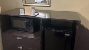 A minibar with a microwave, a refrigerator, and a mirror above it. - Tropical Palm Motel (North Fort Myers)