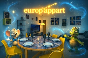 A dining area with a round table, chairs, and a television in the background. - Europ-Appart ~ {Europa-Park / Rulantica} (Huttenheim)