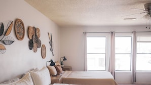 A bedroom with two beds, a ceiling fan, and large windows. - Cosina. equipped. 6 beds 3 large baths. spaces.  (Live Oak)