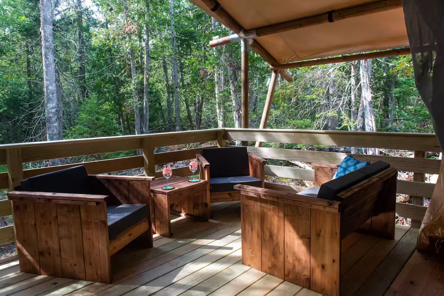 A wooden deck with built-in seating and a canopy.