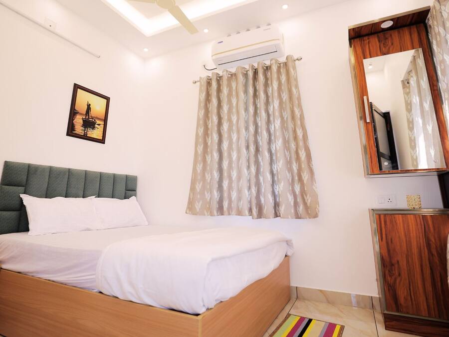 A neatly arranged bedroom with a bed, bedside table, and a mirror.