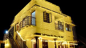 A two-story building with a balcony and string lights. - Wind Castle (Kanayannur)