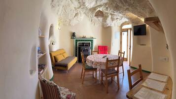 Una habitación acogedora con chimenea, una mesa de comedor y un sofá.