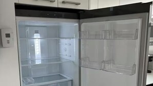 Een roestvrijstalen koelkast met een transparante deur, een bedieningspaneel en een ingebouwd waterdispenser.