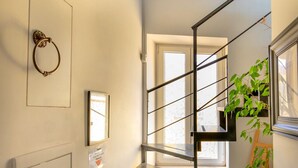 A modern staircase with metal railings and a potted plant on the right. - mimi terrace (Naples)