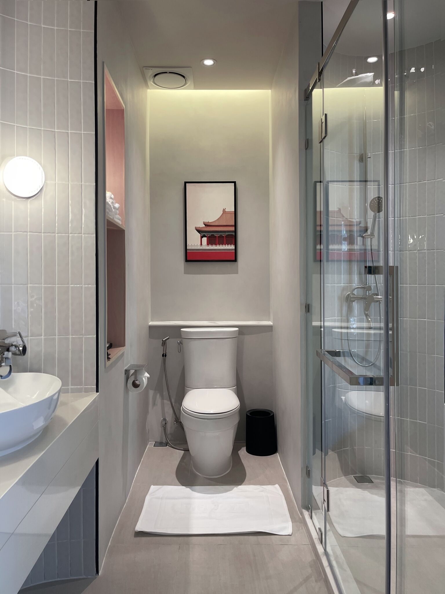 A modern bathroom with a toilet, bidet, and glass-enclosed shower.