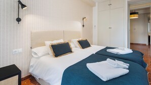 A hotel room with a large bed, two bedside tables, a wardrobe, and a hanging light fixture. - MARA ARENAL. AMPLIO APARTAMENTO EN EL CENTRO DE SEVILLA IDEAL PARA FAMILIAS (Sevilla)