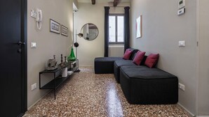 A hallway with a black sofa, a small table with a lamp, and a radiator. - Cá delle Capriate, an intimate retreat at Cà d'Oro (Venezia)