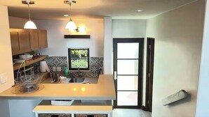 Une cuisine moderne avec des meubles en bois, un four encastré et une fenêtre offrant une belle vue.