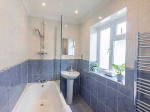 Bathroom features a large bathtub and separate sink area.