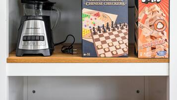 Hyllyllä on kahvinkeitin, shakkilauta ja Jenga-peli.