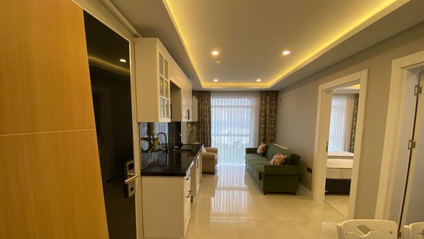 A modern apartment with a kitchen, dining area, and living room.