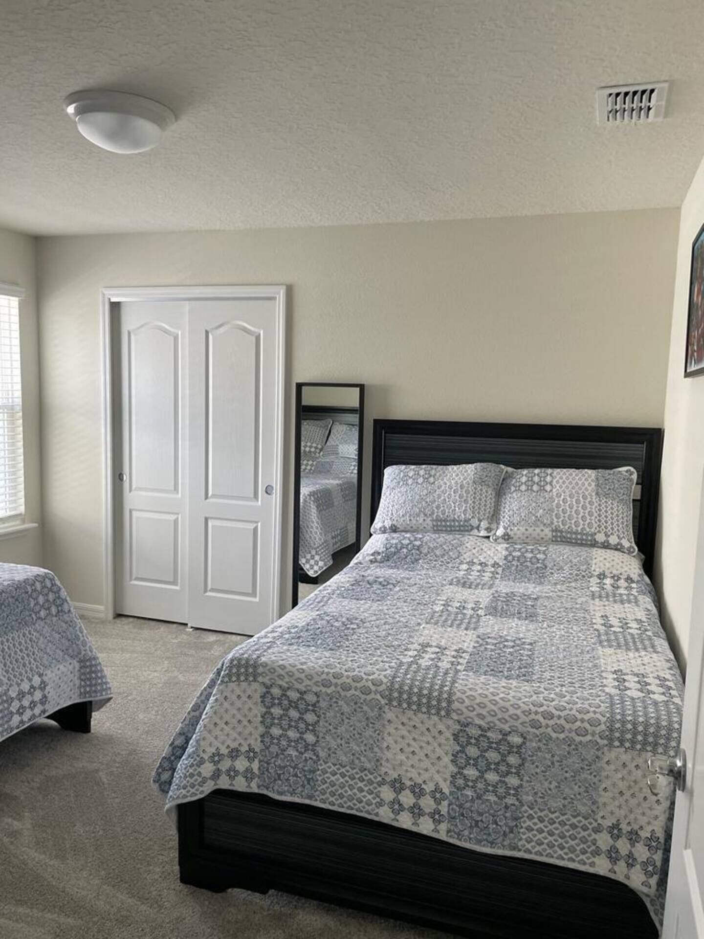 Quarto com uma cama, uma porta e uma janela.