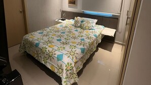 Un dormitorio con cama, mesita de noche y espejo.