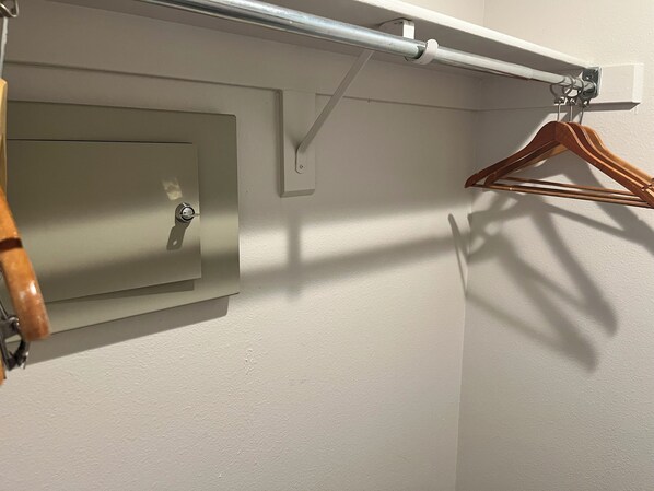 Un porte-manteau mural avec un cintre en bois et un crochet en métal.