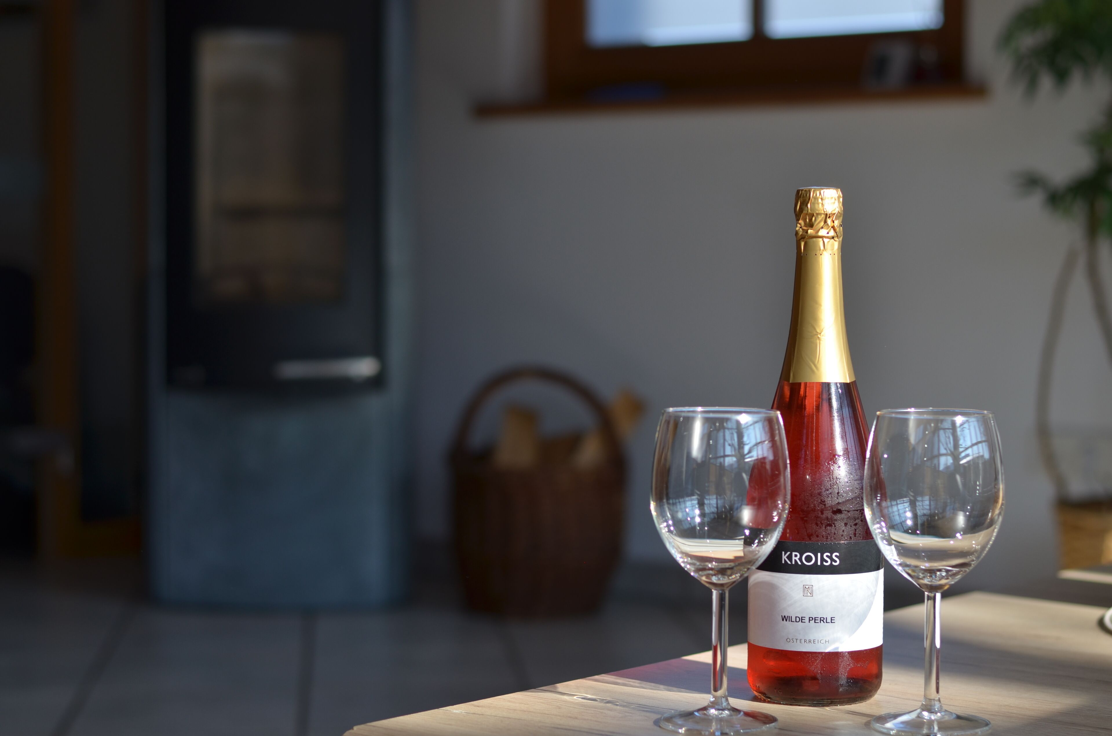 A bottle of wine and two glasses on a table.