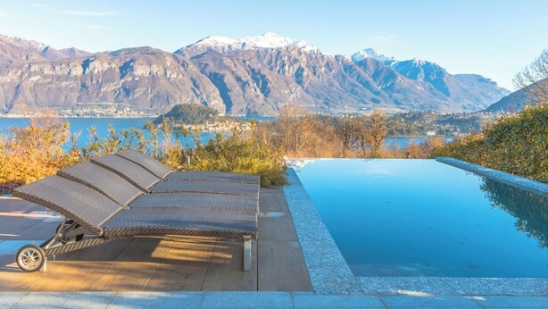 An infinity pool with a mountain backdrop, lounge chairs, and a clear view of a lake and mountains. - Villa Corvina by My Villa Collection (Tremezzo)