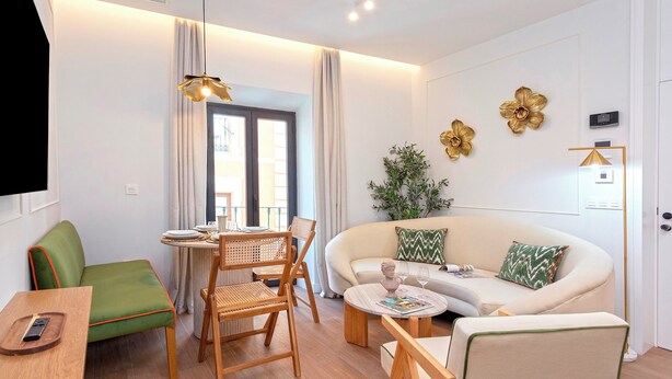 A modern living room with a sofa, chairs, a dining table, and a TV. - Genteel Home Gamazo Terrace II (Seville)