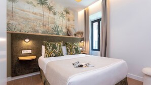 A bedroom with a bed, a nightstand, a mirror, and a wall mural. - Genteel Home Gamazo Terrace II (Seville)