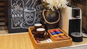 A coffee station with a chalkboard sign, a coffee machine, a vase with flowers, and a basket of coffee pods. - Chic 1BR Retreat: Steps to Rasfannu Beach & Malé’s Best (Malé)