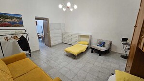 Ein Schlafzimmer mit einem Bett, einem Sessel, einem Kleiderschrank und einem Schreibtisch.