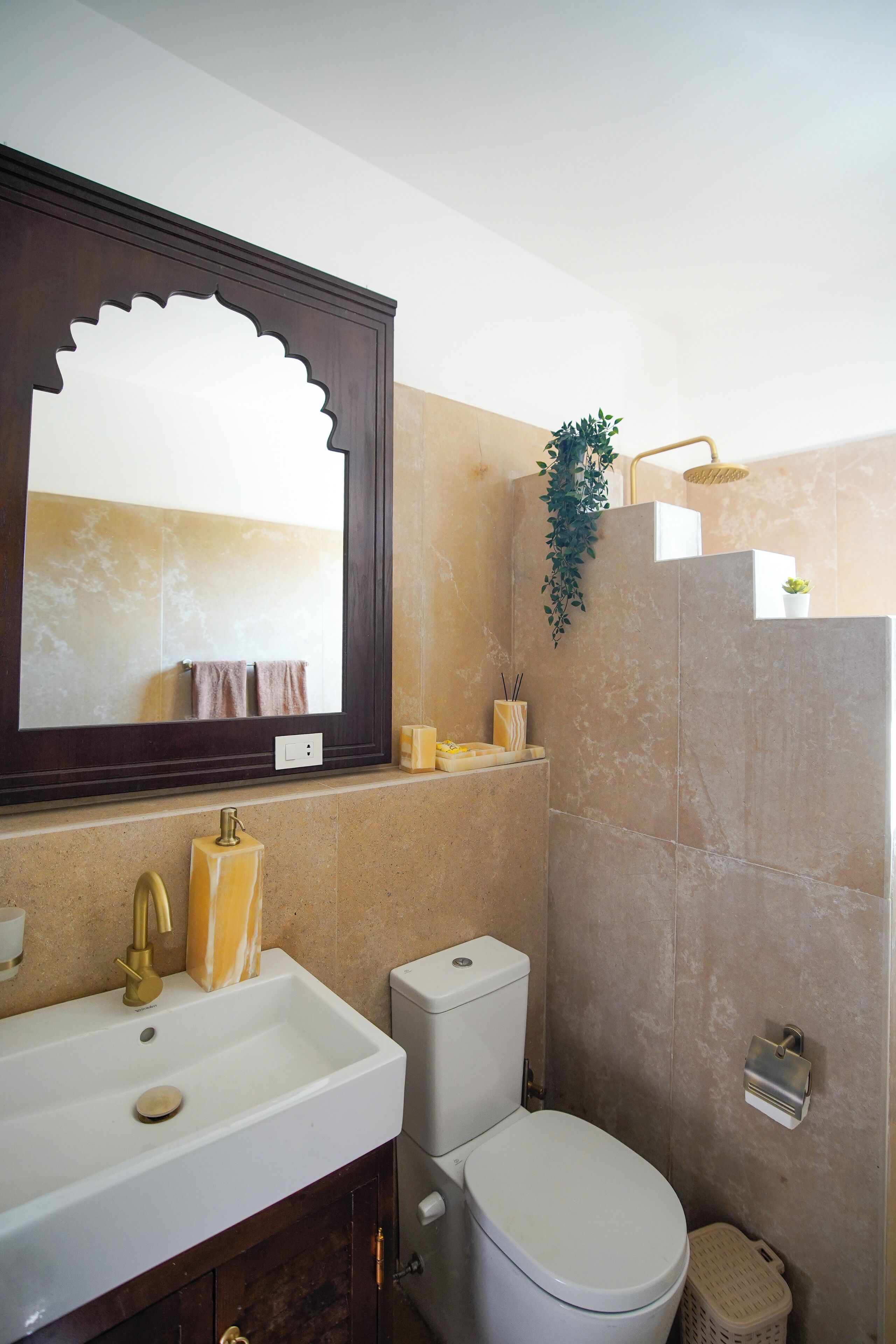 A bathroom with a large mirror, a sink, a toilet, and a shower area.