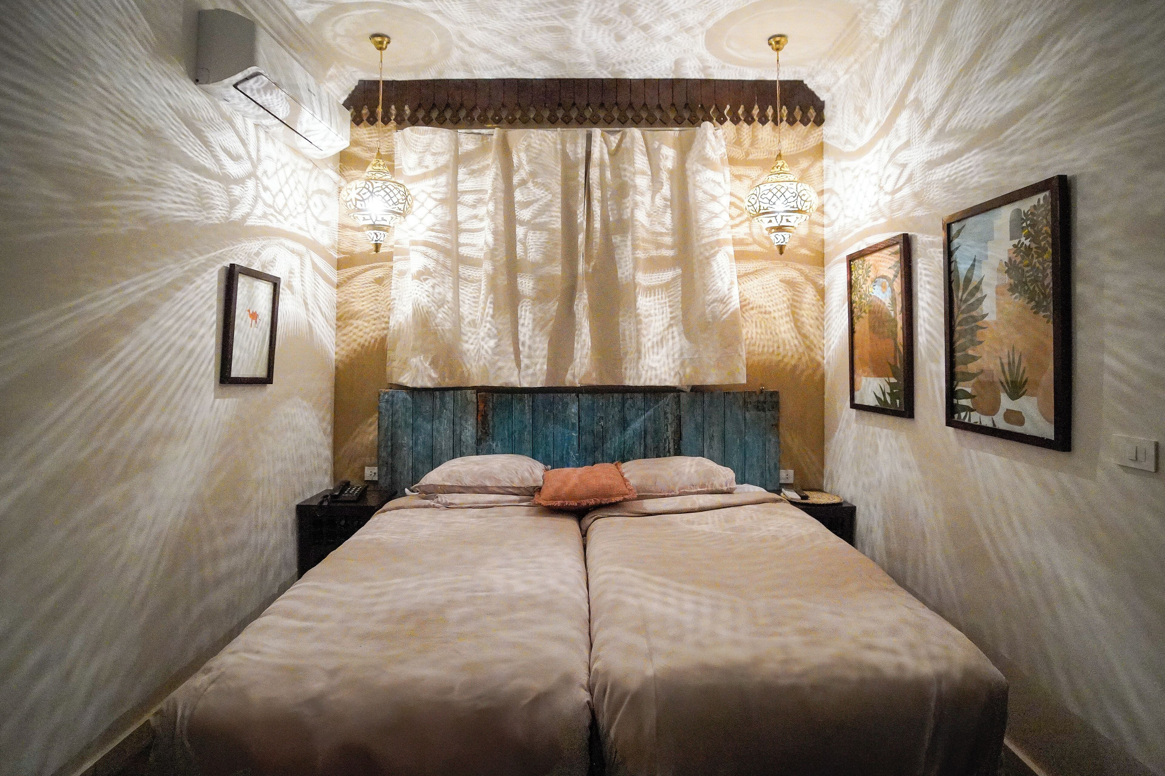 Una cama doble con cabecera de madera, dos mesitas de noche y un cortinaje decorativo.