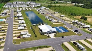 An RV park with multiple parking spaces, a large central building, and a swimming pool. -  RV Lot 67 in Grand Riviera Resort in Foley, AL. Daily and long term available (Foley)