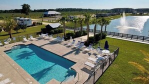 A swimming pool with lounge chairs and a fountain. -  RV Lot 67 in Grand Riviera Resort in Foley, AL. Daily and long term available (Foley)