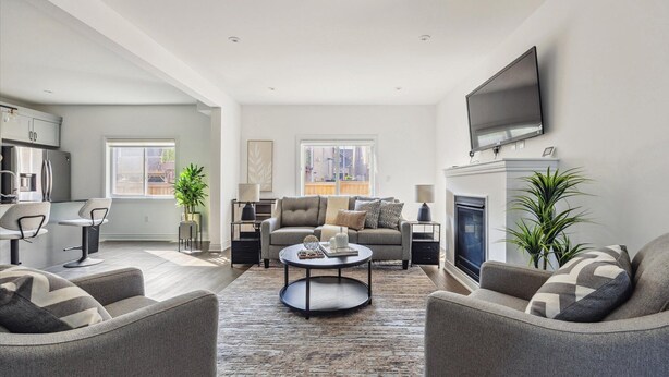 Un salon moderne avec un canapé, des fauteuils, une table basse et une cheminée.