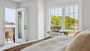 Une chambre dotée d’une grande fenêtre, d’un balcon et offrant une vue sur l’extérieur.