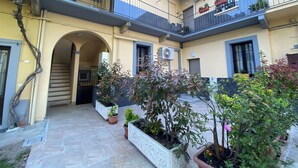 A courtyard with a staircase, potted plants, and a balcony with railings. - Promotion - Fully Equipped Studio for Short and Long Stays in Legnano (Legnano)