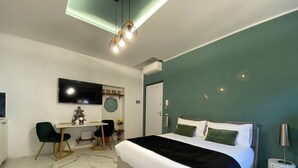 A modern hotel room with a bed, desk, chair, TV, and decorative wall elements. - Promotion - Fully Equipped Studio for Short and Long Stays in Legnano (Legnano)